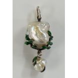 A natural salt water blister pearl pendant set within a green leaf enamel frame with smaller drop