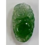 A natural jadeite carving of a Buddha, of semi transparent mottled green colour, 3.