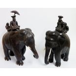 A large pair of carved hardwood elephants each with seated mahout with figure behind holding a