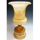 An alabaster campana shaped urn with egg and dart carved rim on waisted column and circular