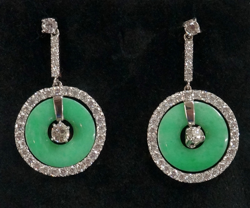 A pair of jadeite and diamond earrings the circular jadeite discs pierced at the centre surrounded