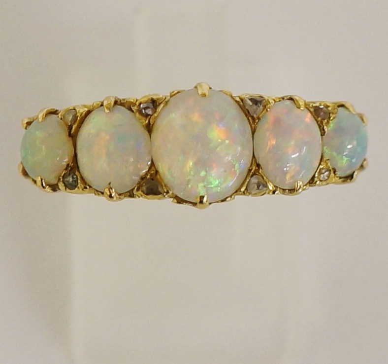 A ladies yellow gold opal ring claw set with five graduated oval opal cabochons,