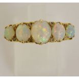 A ladies yellow gold opal ring claw set with five graduated oval opal cabochons,