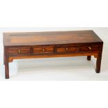 A Chinese hardwood low table, the rectangular panelled top above four short drawers,