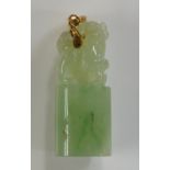 A jadeite pendant carved as a kylin, its right foot raised on a ball, on an oval pedestal,