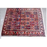 A Persian Bakhtiari carpet worked with five rows of seven varying designs in red and blue,