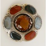 A Scottish hardstone brooch of flower head design with central yellow stone facet cut within an