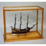 A three masted sailing ship contained within a glazed table top case, case 61cm wide, 28cm deep,