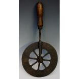 A 19th Century iron cloth measuring wheel with turned handle, numbered 1-24, 8" wheel,