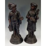 A pair of bronze patinated terracotta figures of a young boy and girl,