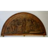 A Victorian oak carved panel of arched shape releif carved with Gaius Mucius Scaevola,