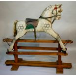 An Edwardian dapple grey rocking horse with carved head, padded seat,