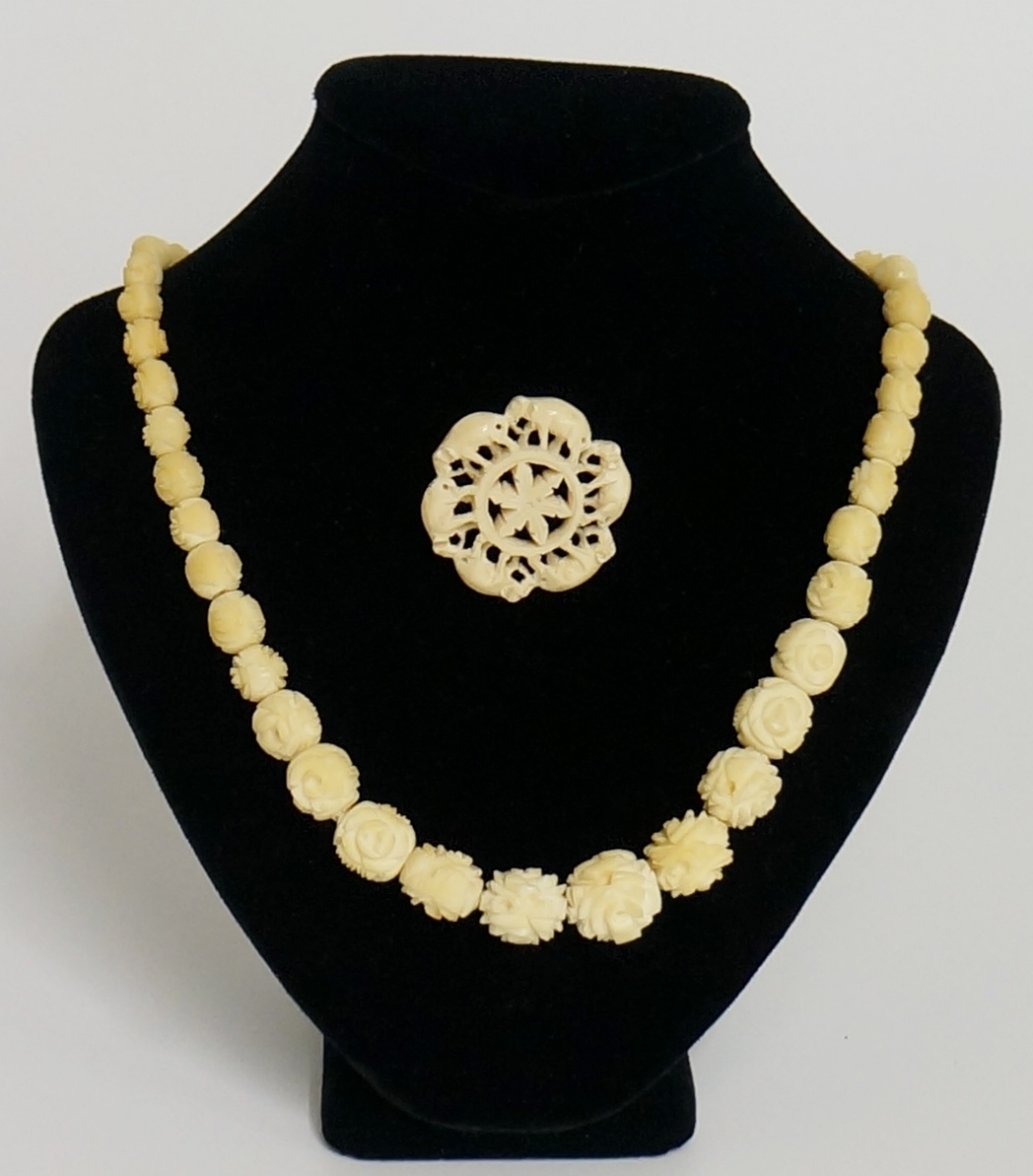 An ivory single row necklace of graduated floral carved beads,