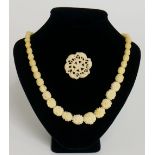 An ivory single row necklace of graduated floral carved beads,
