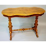 A Victorian serpentine-shaped centre table the butterfly veneered top above a shallow frieze on