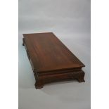 A Chinese hardwood day bed of shallow rectangular form the top with leaf carved lip above a concave