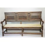 A George II oak three panel settle with applied plain corbels above the three raised fielded panels,