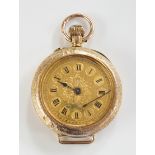 A 9ct gold ladies lapel watch with foliate engraved case,