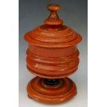 A stained wooden tobacco jar and cover with knopped finial the cylindrical ogee and waisted body on