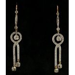 A pair of diamond earrings of interlaced design each set three suspended brilliants on a narrow