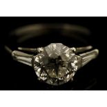 A solitaire diamond ring the circular cut claw set brilliant flanked by diamond set tapered