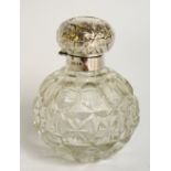 An Edward VII silver topped scent bottle the cushion shaped cover foliate embossed with vacant