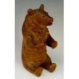 A seated bear inkwell the hinged head revealing glass well, 17cm high,