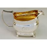 A George III boat shaped cream jug with reeded rim and angular handle,