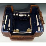 A ladies leather travelling case the blue silk lined interior with five silver topped jars,