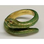 An 18ct yellow gold and green enamel serpent ring with gem set eyes, stamped .