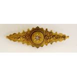 A Victorian 15ct gold brooch the raised circular centre gypsy set with a diamond brilliant within