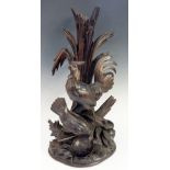 A carved group of cockerel and chicken with bowl on a corn and branch and leaf base, 48cm high,