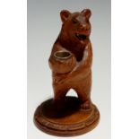 A standing bear thimble holder with glass eyes and open mouth, circular base, 12cm high,