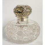 An Edward VII silver topped scent bottle the hinged bun shaped cover foliate embossed and lobed