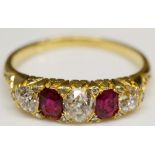 A yellow gold ruby and diamond ring, the pair of oval cut rubies flanked by round cut brilliants,