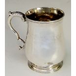 A George III tankard  of baluster shape with leaf capped scroll handle, plain circular foot,