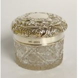 An Edward VII silver topped jar the slightly domed cover embossed with leafy scrolls and panels