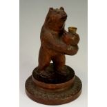 A standing bear thimble holder its paws outstretched, circular spreading base, 15cm high,