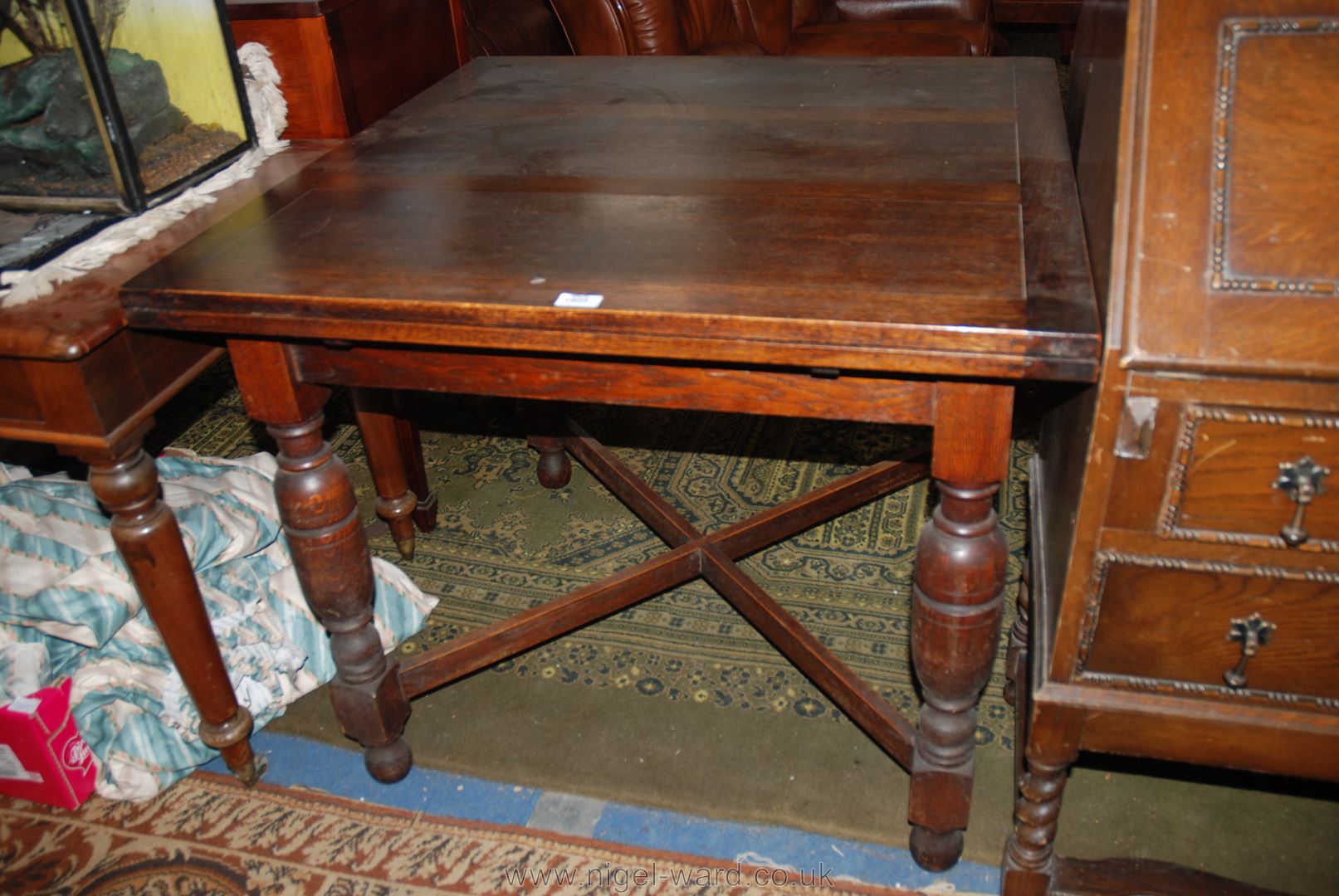 A 1940's Oak draw-leaf extending Dining Table, having rectangular top and leaves, standing on