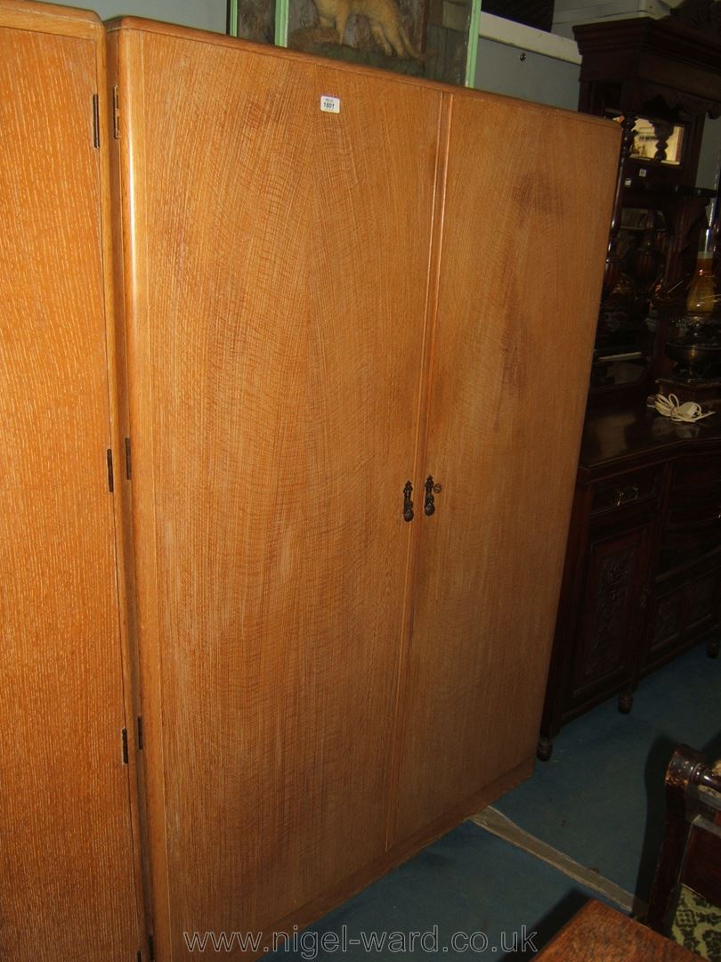 A 1970's limed oak Double Wardrobe with moulded edges, the doors opening to reveal a suspended