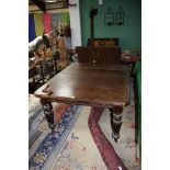 A late Victorian Oak wind-out extending dining Table, having rectangular cut corner top, moulded