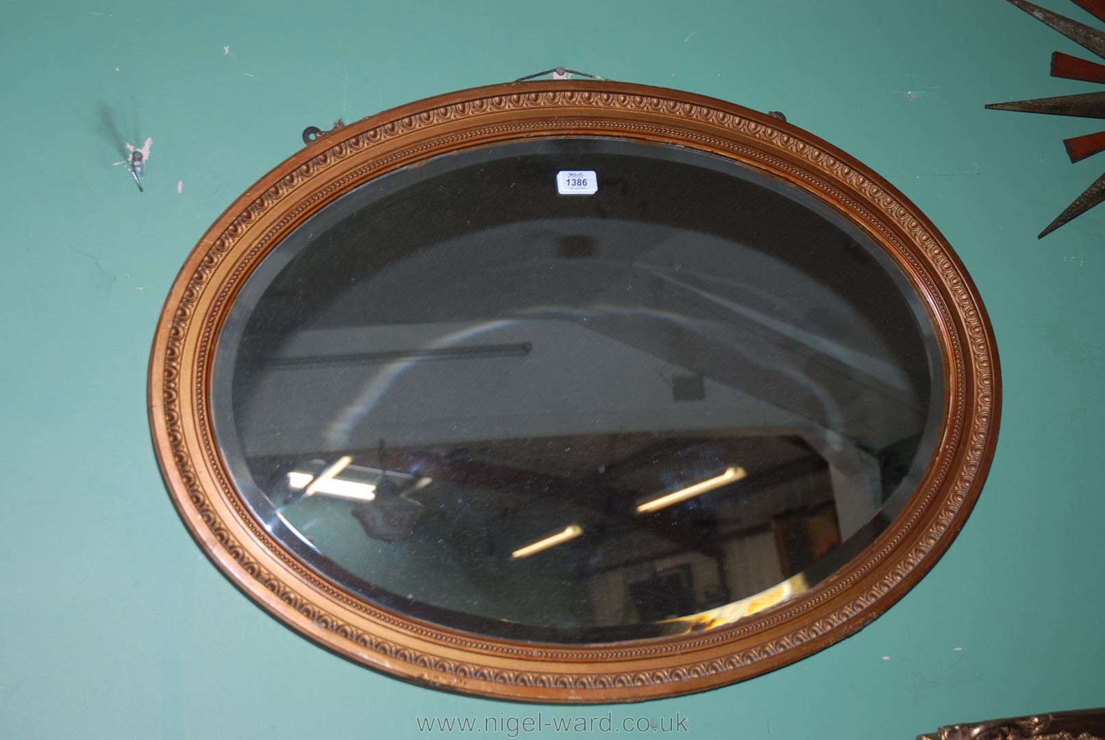 A large oval mantle Mirror with gilt coloured moulded frame.