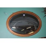 A large oval mantle Mirror with gilt coloured moulded frame.