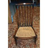 An Arts and Crafts Beech framed Nursing Chair, wavy slat back, cane seat,