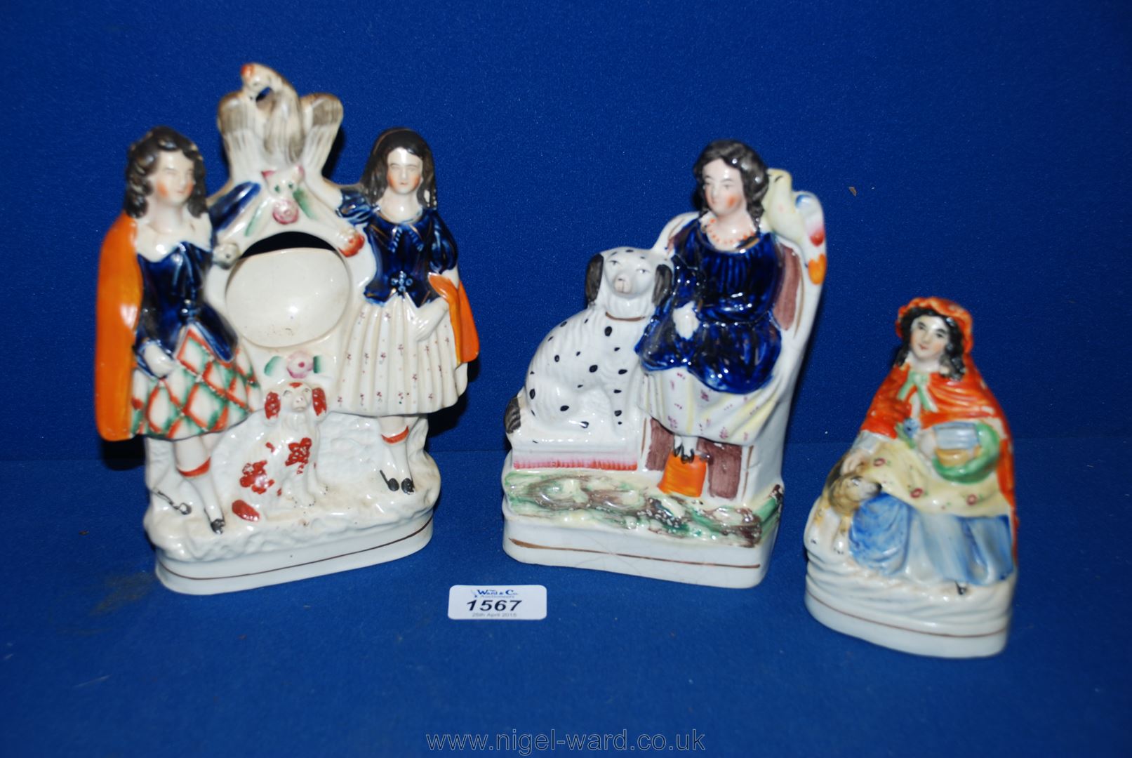 Three Staffordshire flatback figures including clock stand, and two of Ladies with their dogs