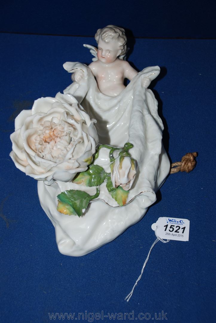 A continental porcelain Wall Pocket with a cherub holding a swag with a large rose.  Some damage.