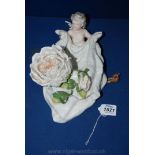 A continental porcelain Wall Pocket with a cherub holding a swag with a large rose.  Some damage.