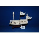 A finely carved Chinese ivory River Boat with flags and lamp and 15 figures,