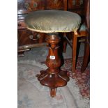 A Victorian adjustable Piano Stool with green upholstered seat.