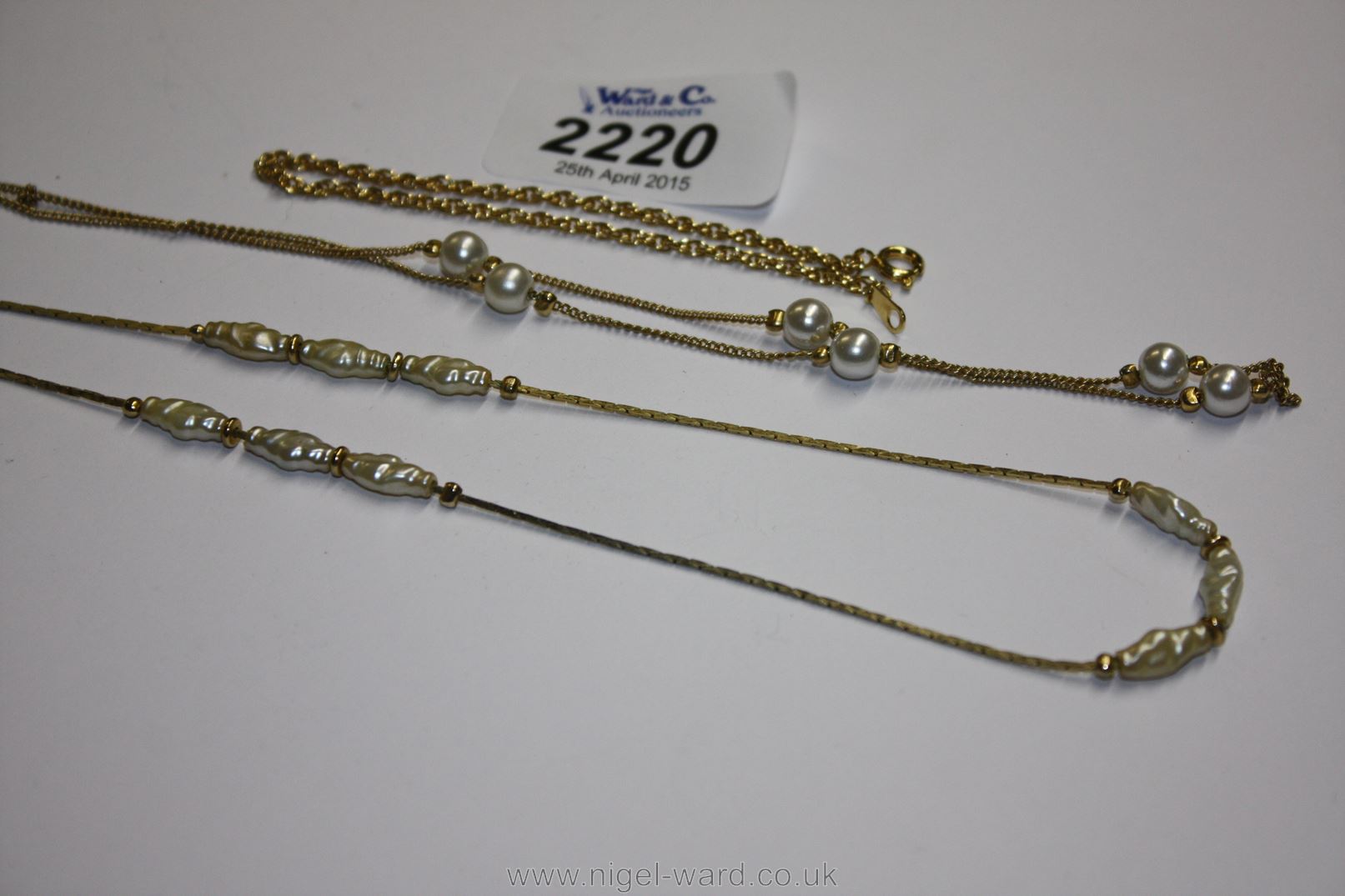 A yellow metal Chain with spaced pearls,